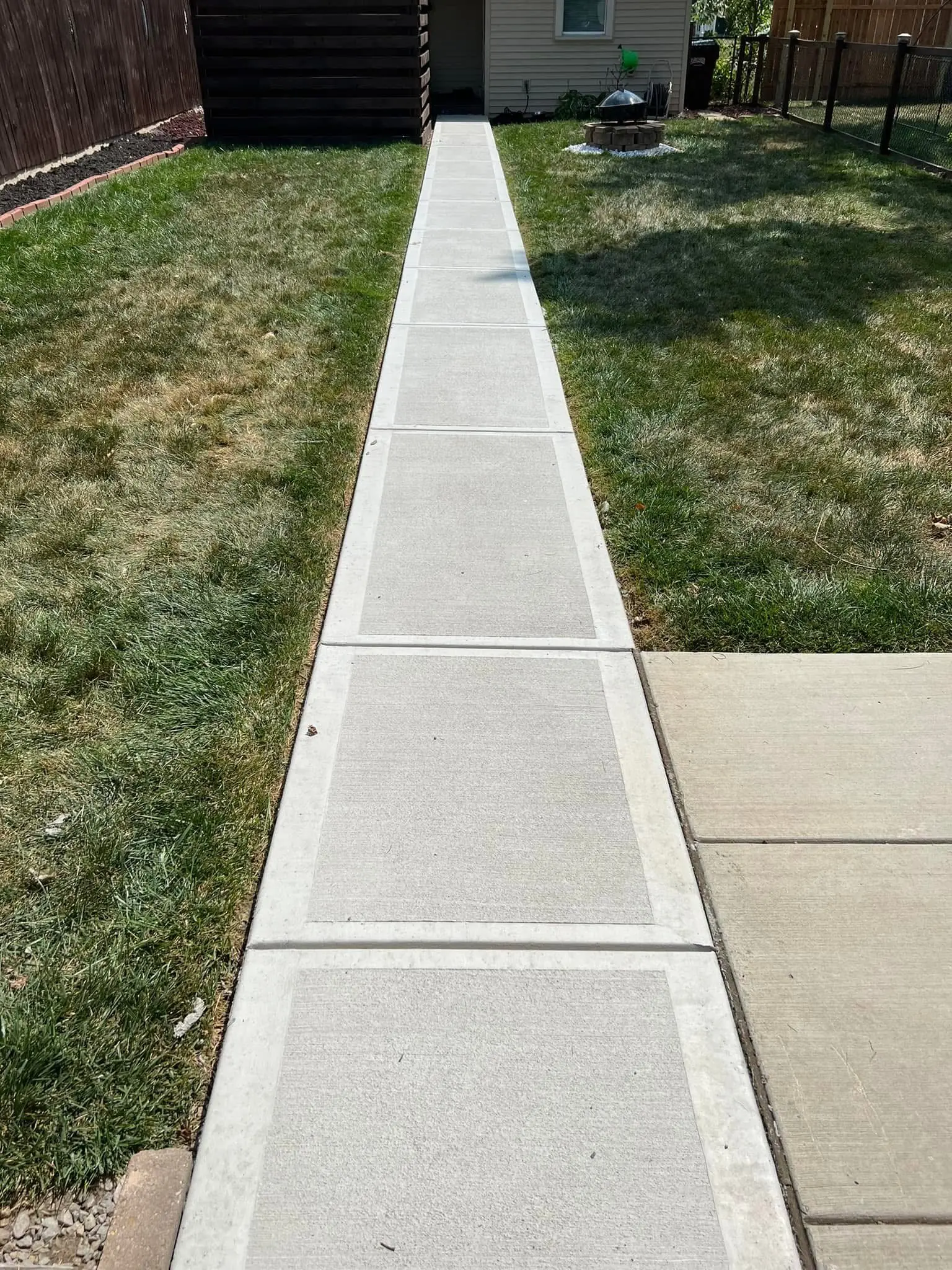 New concrete backyard walkway with clean expansion joints