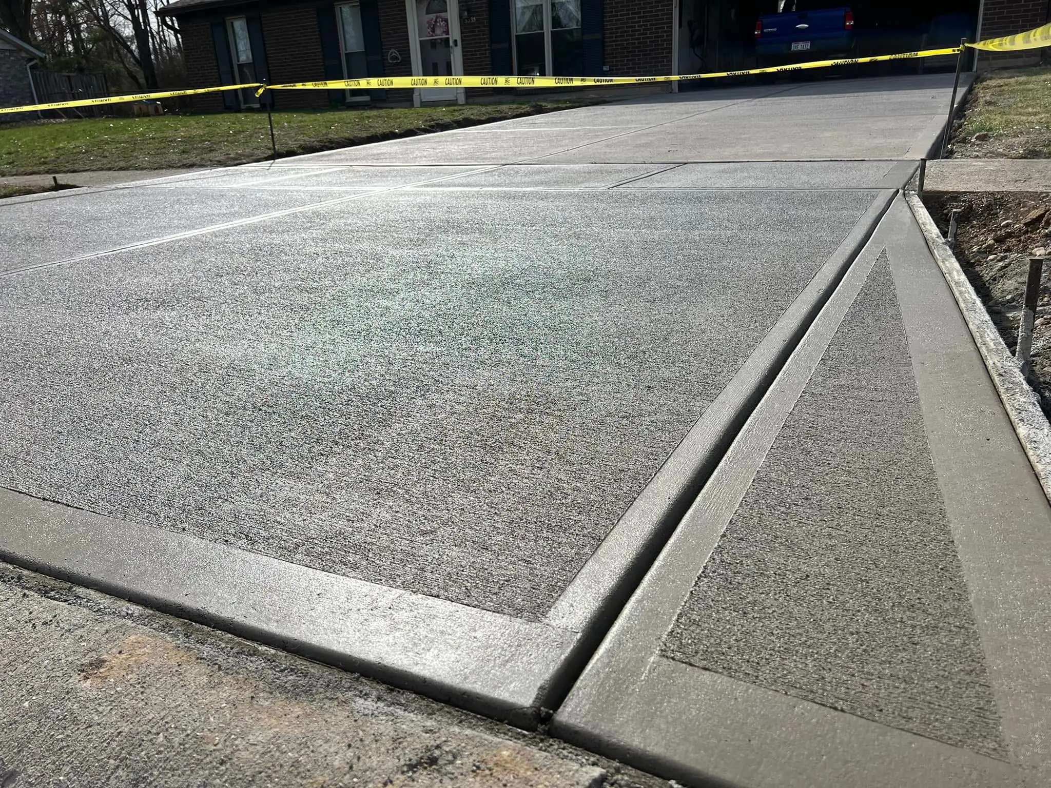 New concrete driveway apron with exposed aggregate broom finish